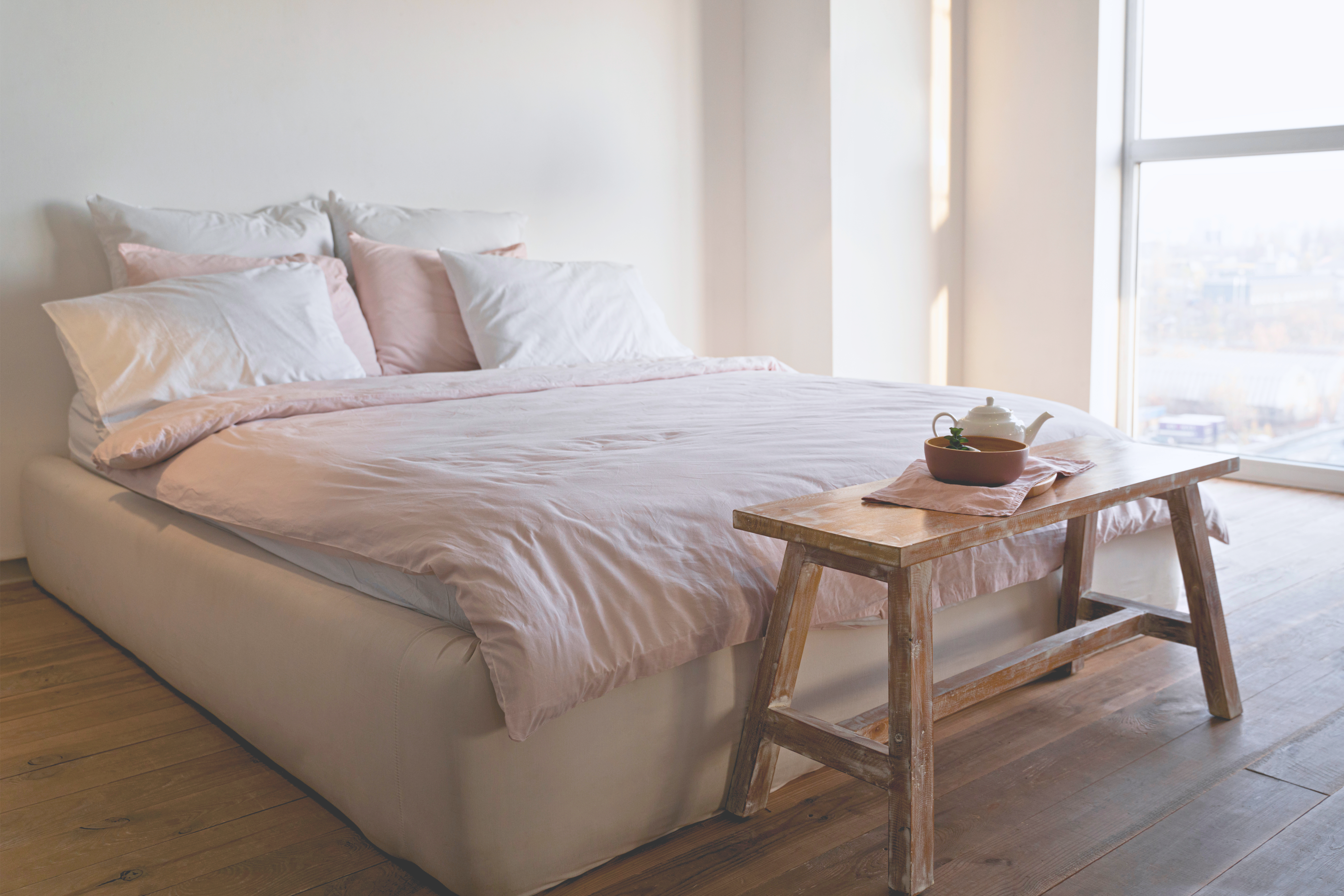 Lit avec literie haut de gamme dans une chambre lumineuse au design épuré